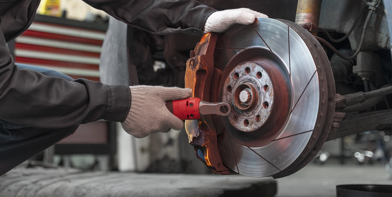mécanicien calibrant des disques de freins sur une roue