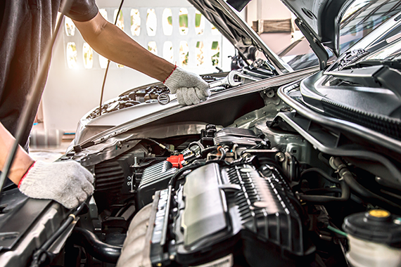 mécanicien penché sur le moteur d'un véhicule